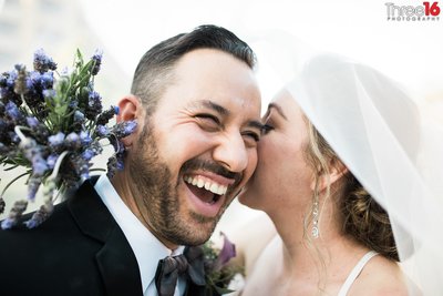 Bride whispers in her Groom's ear causing him to laugh