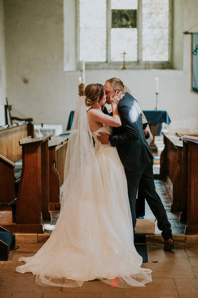 Just married couple kissing in church pews