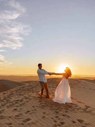 Phoenix Arizona Couple spinning at the sand dunes during their engagement session.
