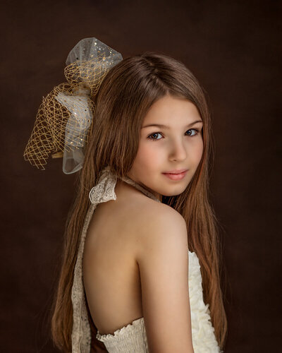 girl in cream and gold with bow in fine art style