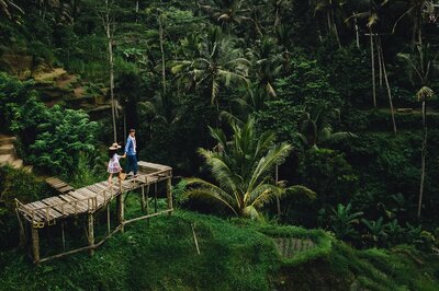 bride and groom walk out onto bridge in jungle of Bali