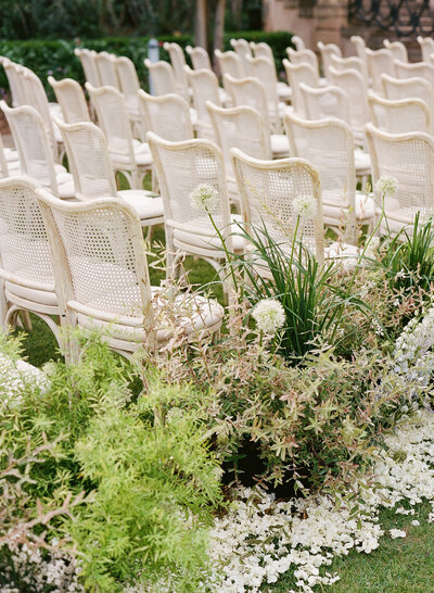A couple snuggles together on their wedding day, the bride holding an Anthousai bouquet that is all white.