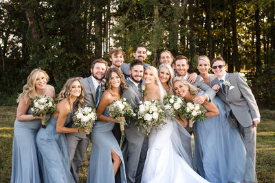 Wedding party huddled together for group picture outside