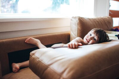 child watching TV on the couch and smiling