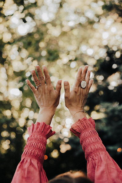 a womans hands out stretched to the sky 