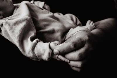 Foto van de hand van papa en de baby tijdens een fotosessie in de Wageningen 
