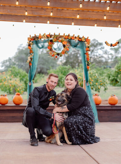 Couple smiling with their dog after their wedding ceremony in Northern California.