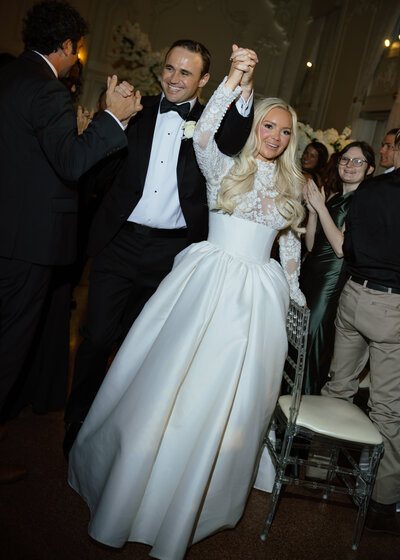 As the bride and groom made their grande entrance, family and friends shared their cheers and joy in preparation for the first dance between the two.