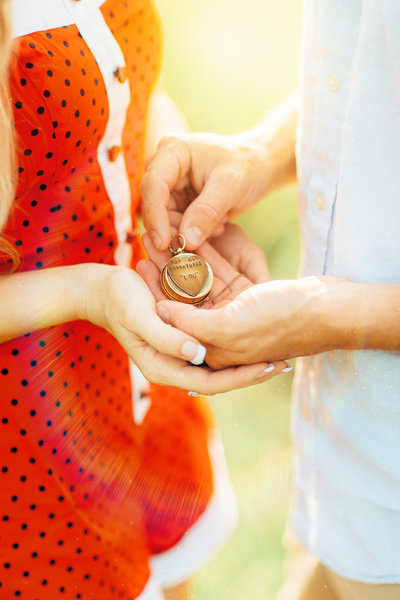 couple holding in their hands an engagement & proposal gift in the bright airy sunlight