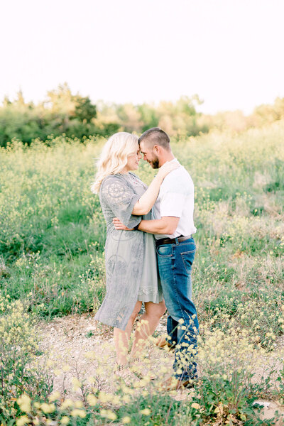 Man kisses woman on the forehand at engagement shoot in Dallas Texas