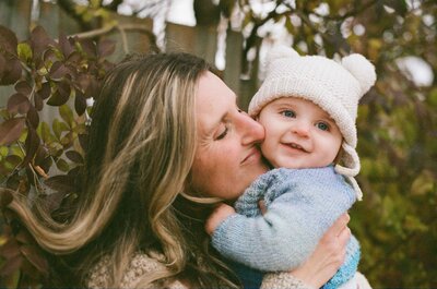 a mom snuggling her face beside her baby outside in Port Perry, Ontario.