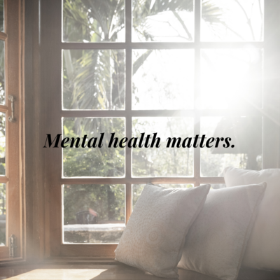 A view of a window with sun coming in and plants outside. Black text reads 'Mental Health Matters'