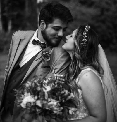 Bride and groom touch noses and smile at each other during Whispering Trees Manor wedding