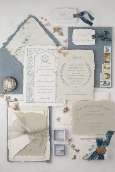 Elegant wedding invitation suite against a powder  blue background