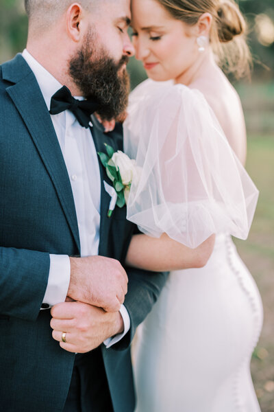 Close up image of a bride and groom's arms interlocking