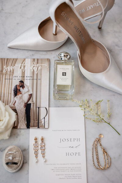 wedding shoes, perfume, and jewelry with the invitation suite