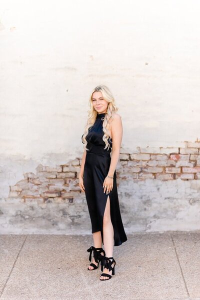 Girl in black dress posing for urban senior session in downtown Latrobe, PA