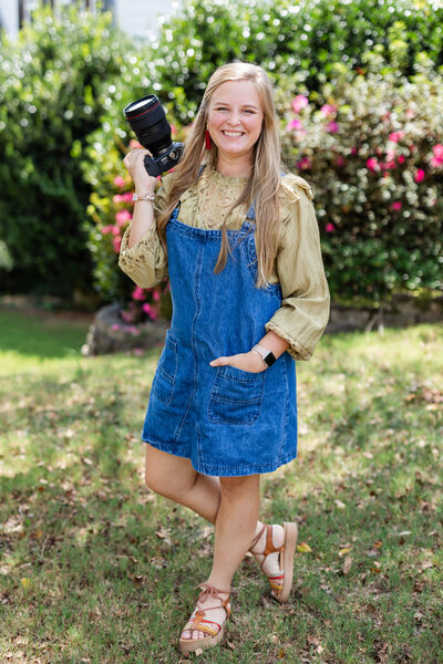 Nicole standing in a Catholic Church holding a camera