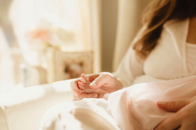 A mother holding her newborn baby's feet. 