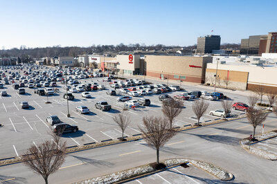Drone photograph of a shopping center and parking lot.