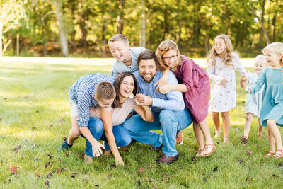 Young couple posing for engagement photo in pink bushes