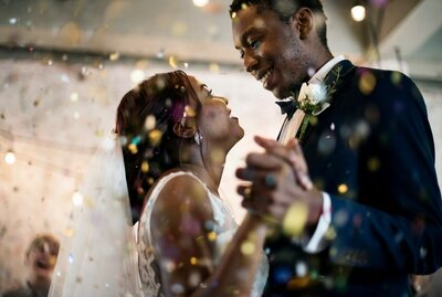 Couple dancing joyfully during their wedding surrounded by confetti