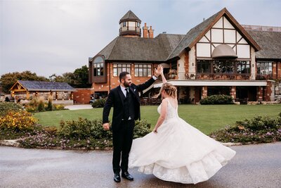 The groom caresses his brides face in front of the glass chapel leaning in for a kiss