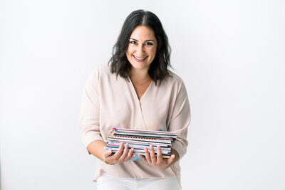 woman holding a stack of magazines