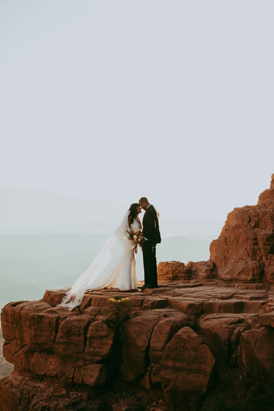 bride and groom kissing on mountaintop