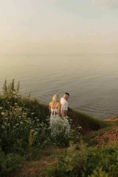 couple walking towards ocean for lifestyle photos in prince edward island