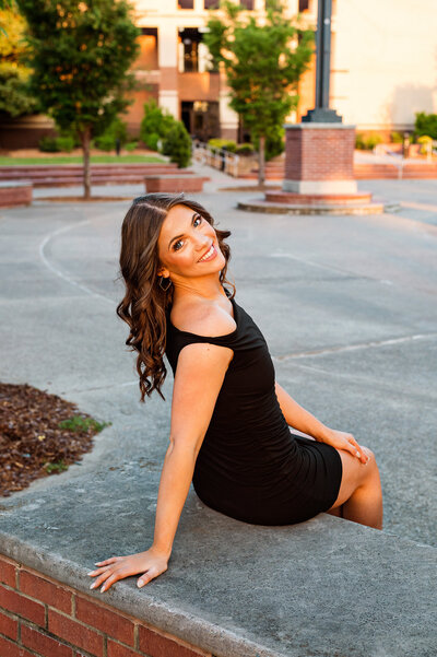 Chi Omega senior wearing graduation stole and standing at traditional horseshoe at MTSU