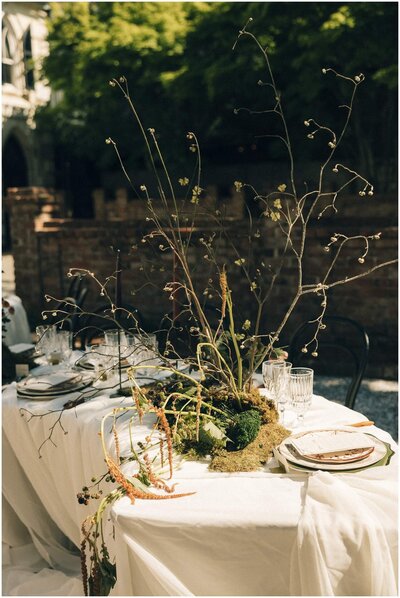 Details of a unique floral centerpiece on a long curved table