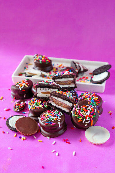 a stack of Oreos and Reese's cups dipped in chocolate