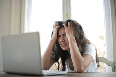 Woman pushing her fingers through her hair in a frustrated way