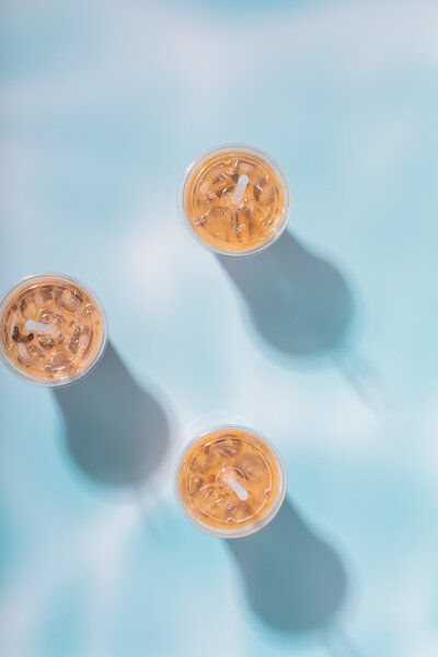 Full Coffee Cups on Blue Background - Daylight Donuts