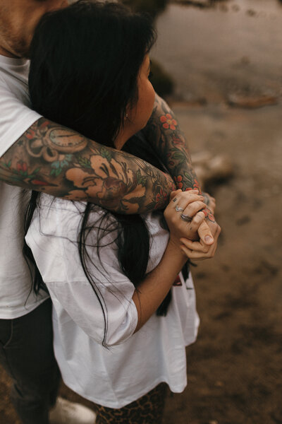couple by the river with tattoos at Golden Hour 