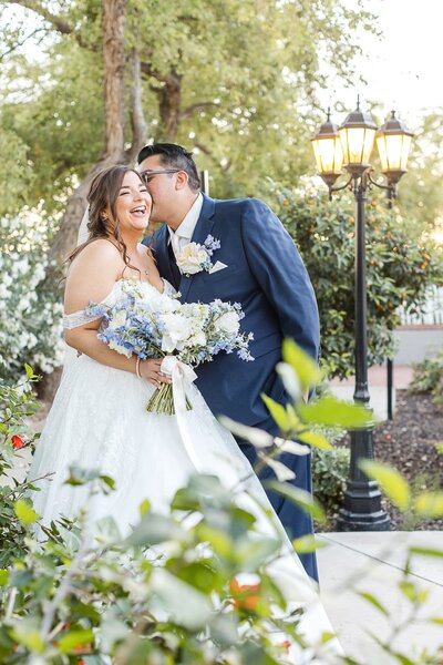 Phoenix-Wedding-Photographer-and-Videographer-Groom-kissing-Bride-on-Cheek-QuiWed-1546