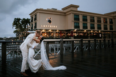 Couple dressed in wedding attire dancing on jetty at Marina Mirage.