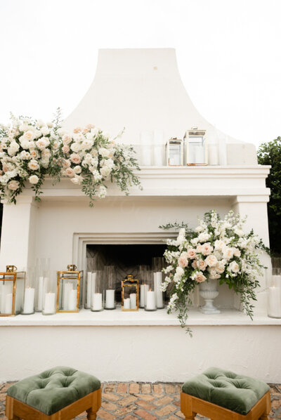 fireplace with lanterns, candles, and florals