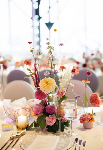 Colourful, bright, centrepiece flowers at a Science Centre wedding reception. 