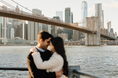 couple standing in front of brooklyn bridge in new york