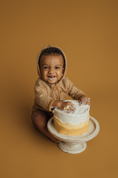 boy on mustard eating cake for cake smash pictures in tampa