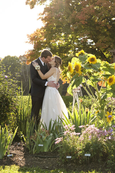 Bride and groom kissing in an outdoor garden.