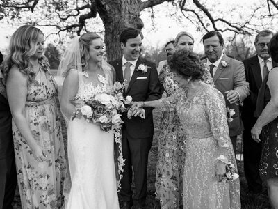 Black and white photo of bride and groom with their grandma and bridal party