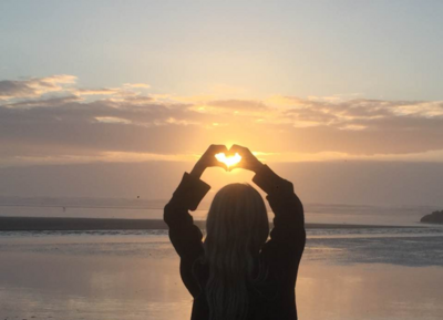  heart hands in front of the suns rays 