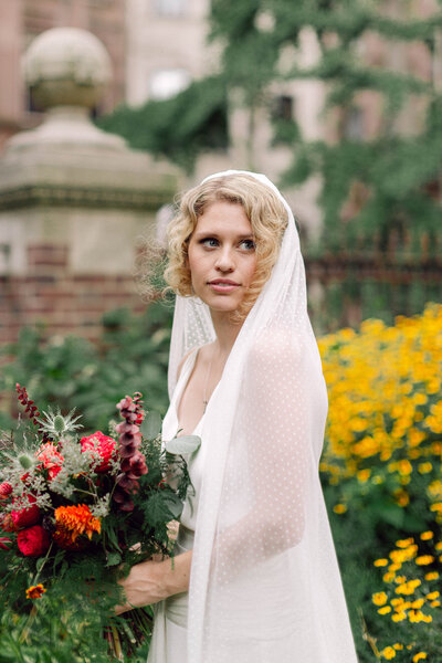 Bride elegantly posing with her veil during a New York City wedding