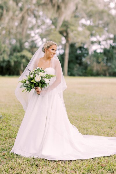 Stunning bride holds her wedding bouquet in bridal portrait