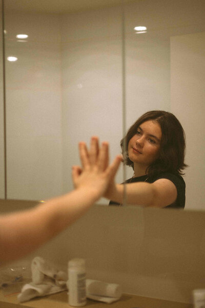 Sunshine Coast portrait of a teenage girl reaching for her reflection, captured in soft storytelling style.