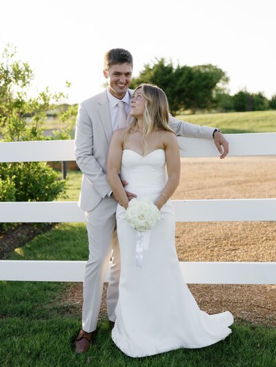 Bride surrounded by bridesmaids in colorful dresses, holding vibrant bouquets inside a bright chapel.