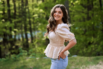 Senior with hands on her hips with trees in the back | Senior Portraits